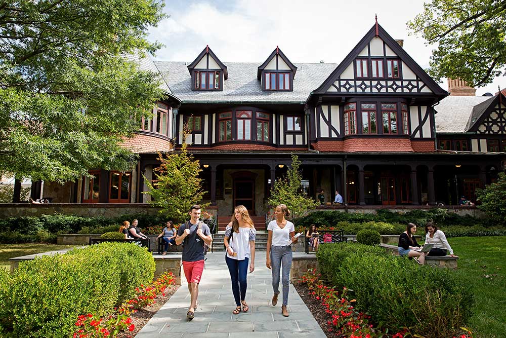 three students walk in front of Humanities